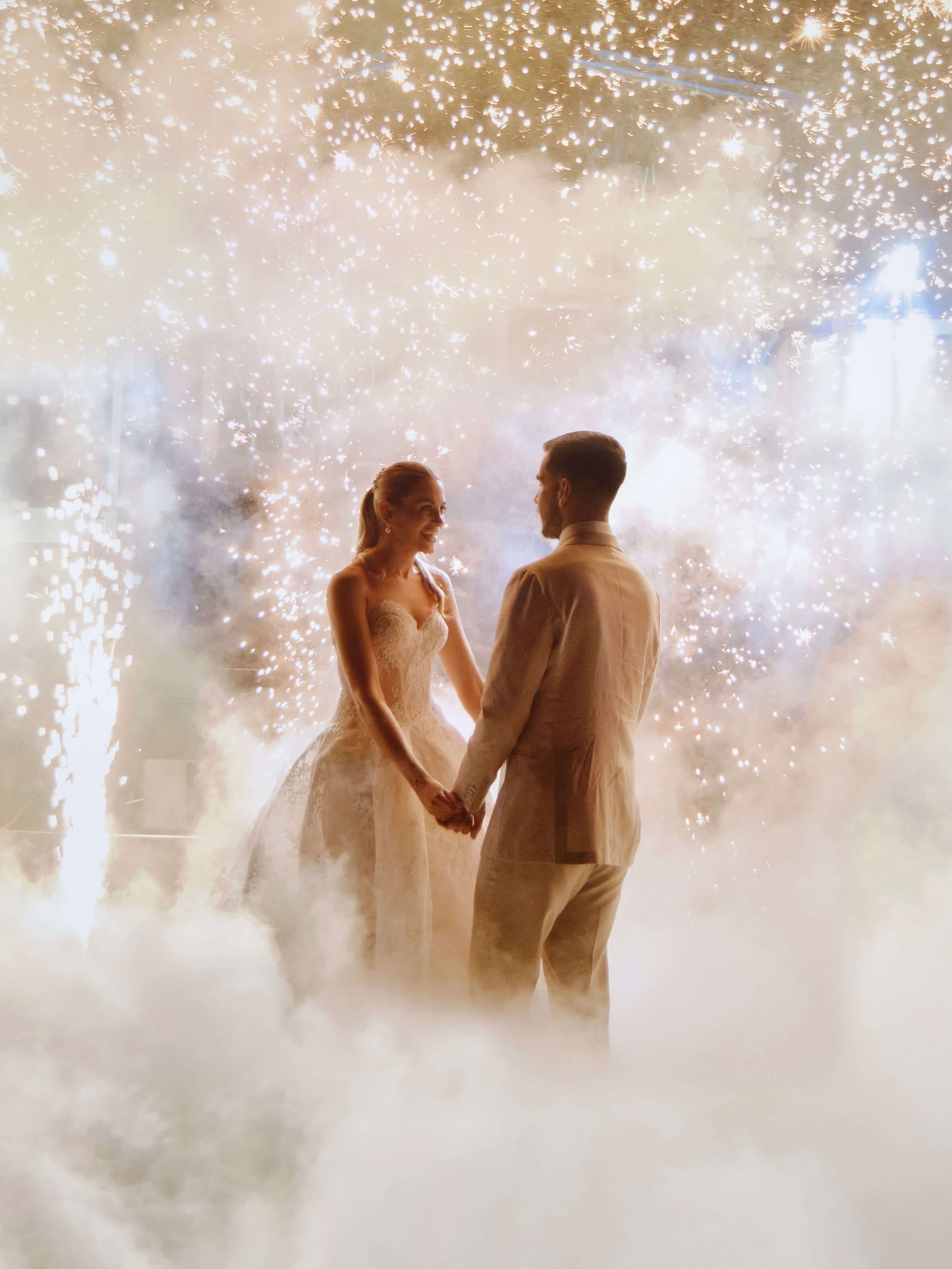 Novios sonriendo con pirotecnia de fondo, fotografía de boda con estilo editorial por Andreagsfoto en la Isla de Margarita, Venezuela